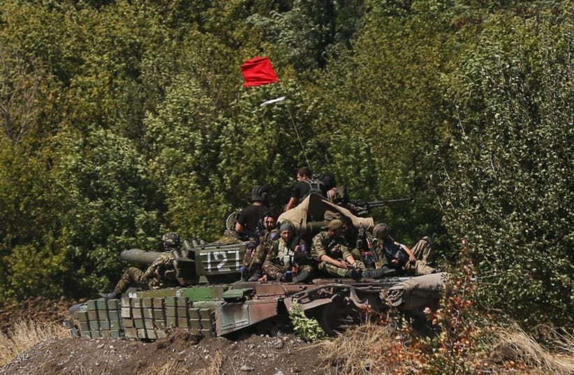 Pro-Russian separatists sit on a tank at a position near Donetsk, eastern Ukraine, September 2 (photo credit: REUTERS)