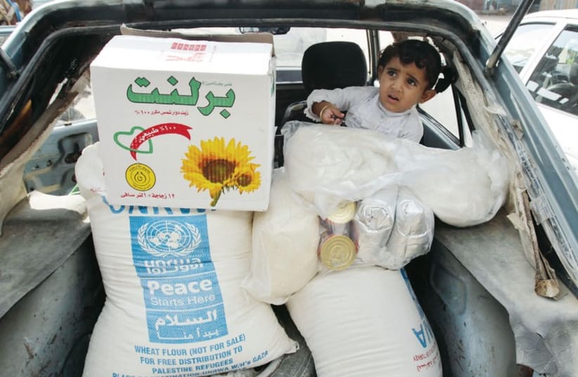 A palestinian child sits in a car after her family received food supplies from the UNRWA headquarters in Rafah in the southern Gaza Strip, in this photo from November, 2012 (photo credit: REUTERS)