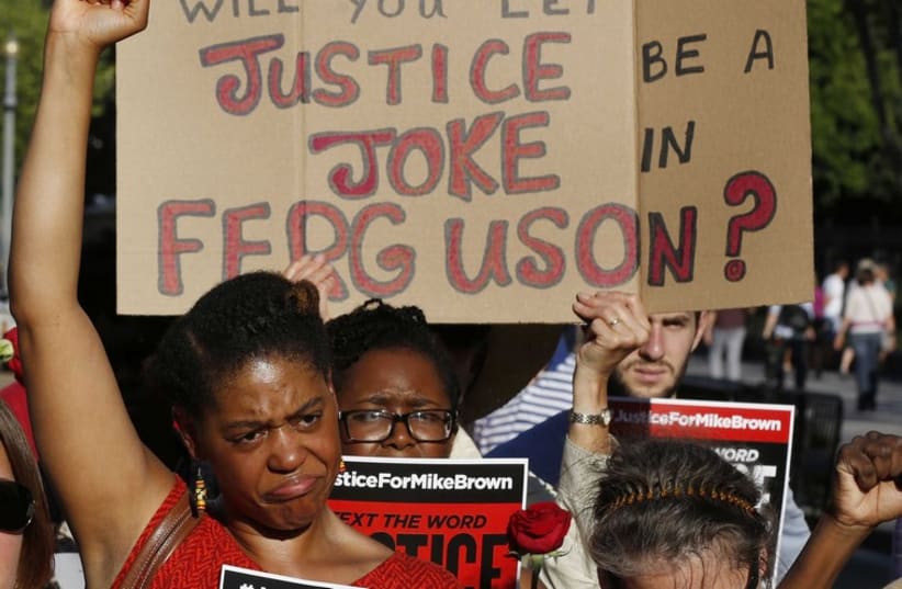 Protesters call for a thorough investigation of the shooting death of teen Michael Brown in Ferguson, Missouri, on a street in front of the White House in Washington. (photo credit: REUTERS)