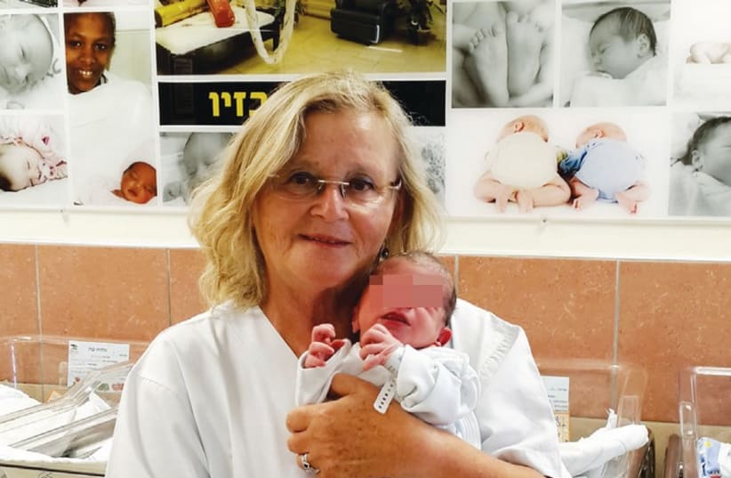 Esther Ambar, the nurse in charge of the Neonatal Department at the Ziv Medical Center, with the seventh Syrian baby born at the hospital. (photo credit: Courtesy)