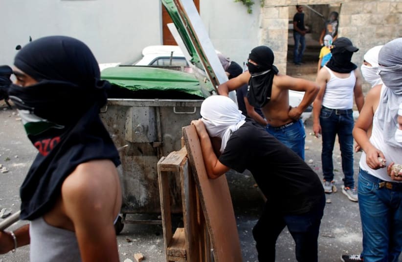 Palestinian protesters take cover during clashes with Israel Police in the east Jerusalem neighborhood of Wadi Joz September 7, 2014. (photo credit: REUTERS)