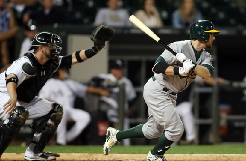 Chicago, IL, USA; Oakland Athletics second baseman Eric Sogard hits a two-run single against the Chicago White Sox during the ninth inning at US Cellular Field. (photo credit: REUTERS)