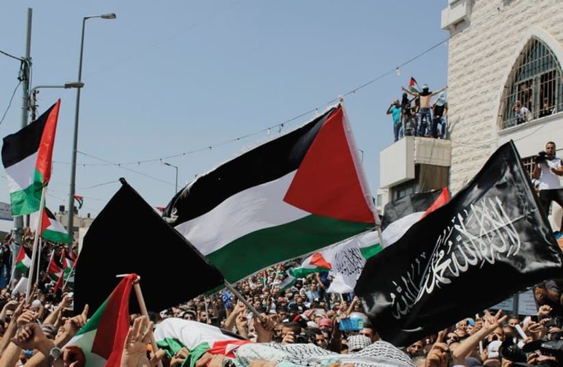 THE FUNERAL of Muhammad Abu Khdeir in Jerusalem featured many black flags, and commentators have been asking whether this portends a religious and political change of attitudes. (photo credit: REUTERS)