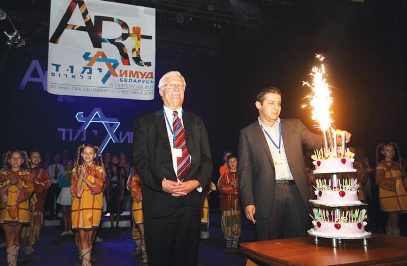 THE JOINT DISTRIBUTION COMMITTEE’S new Belarus country director Alex Kushnir lights 100-year-old philanthropist Ralph Goldman’s birthday cake in Vitebsk with Limmud founder Chaim Chesler and event performers looking on. (photo credit: YOSSI ALONI)