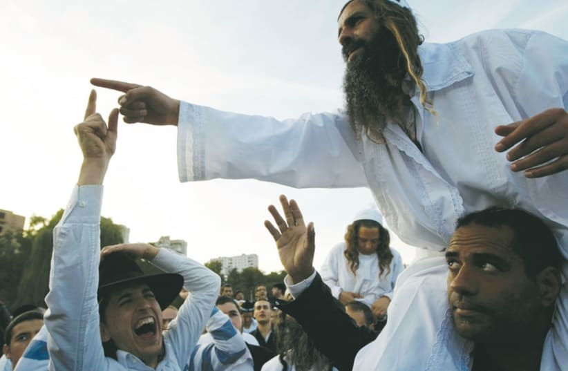 Men gesticulate on the banks of a lake in Uman in September 2010. (photo credit: REUTERS)