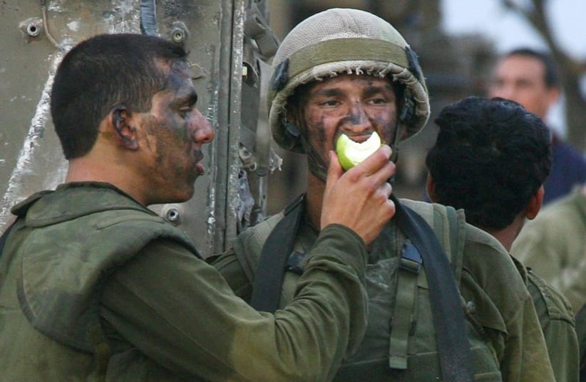 Israeli soldiers share an apple (photo credit: REUTERS)