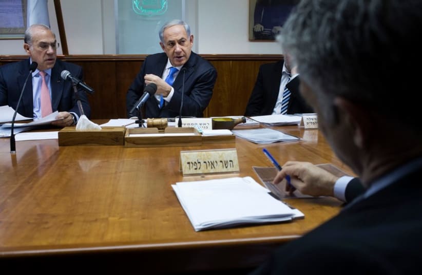 Finance Minister Yair Lapid (R) sits across from Prime Minister Binyamin Netanyahu at the cabinet meeting in Jerusalem. (photo credit: REUTERS)