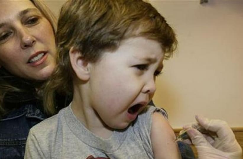 Four year-old Jonathan Nies reacts as he receives a flu vaccination at Children's Hospital Boston in Boston, Massachusetts.  (photo credit: REUTERS)