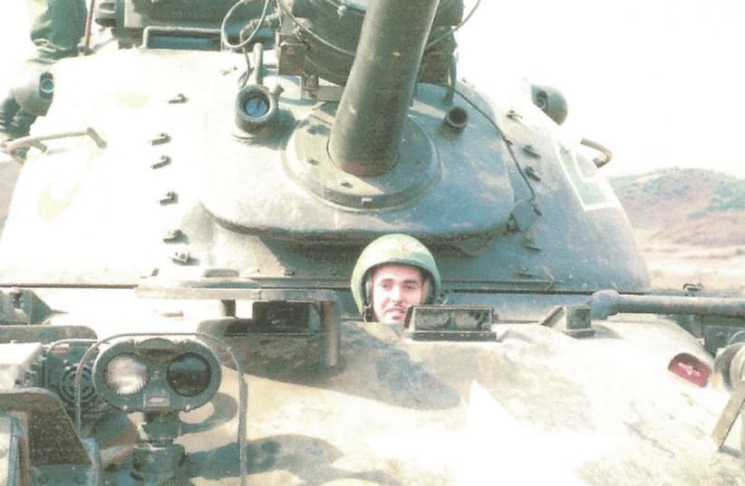 Chaplain Greenspan pops his head out of a tank. (photo credit: ALAN GREENSPAN)