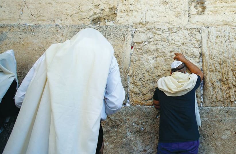 Men pray at the Western Wall in Jerusalem. (photo credit: REUTERS)