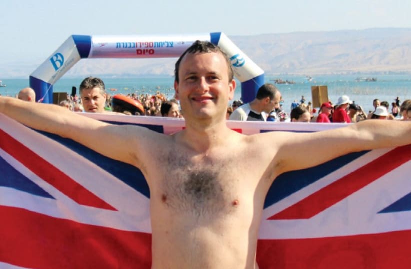 BRITISH AMBASSADOR Matthew Gould swims proudly for the flag in the Sea of Galilee. (photo credit: BRITISH EMBASSY IN ISRAEL)