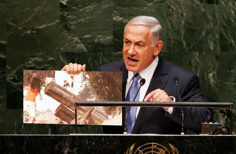 Israel's Prime Minister Benjamin Netanyahu holds up a photograph as he addresses the 69th United Nations General Assembly (photo credit: REUTERS)