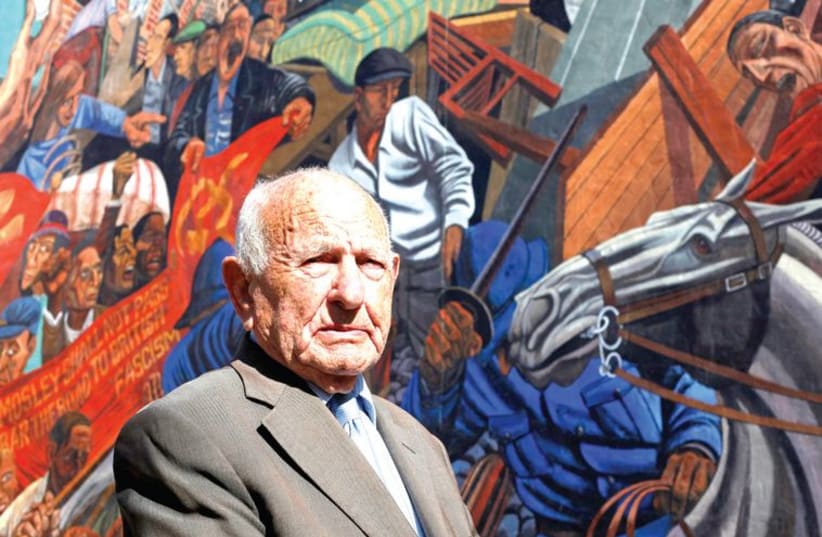 Max Levitas, 96, who participated in the 1936 ‘Battle of Cable Street’, poses 75 years later in front of a mural depicting the clash. (photo credit: REUTERS)