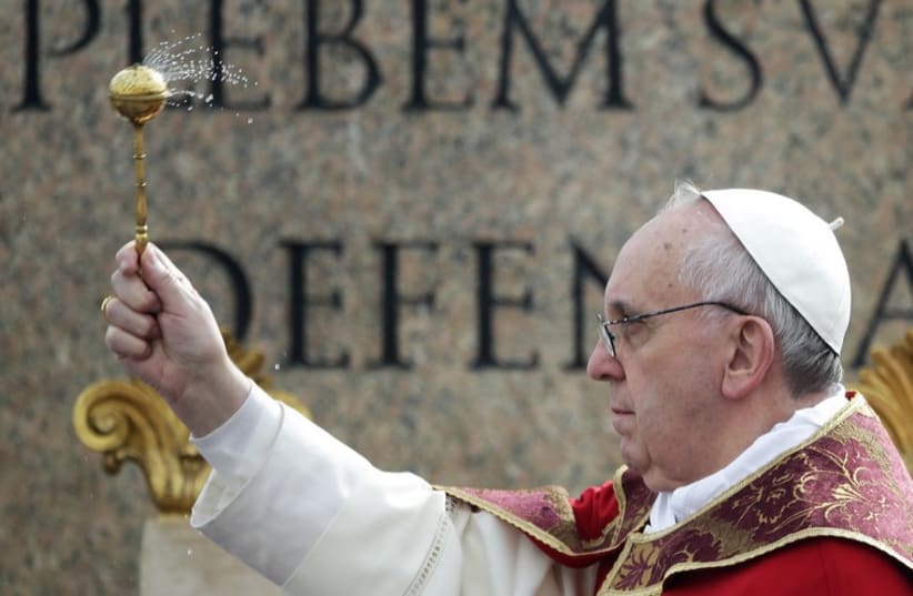 Pope Francis sprinkles holy water with an aspergillum at Saint Peter's Square at the Vatican (photo credit: REUTERS)