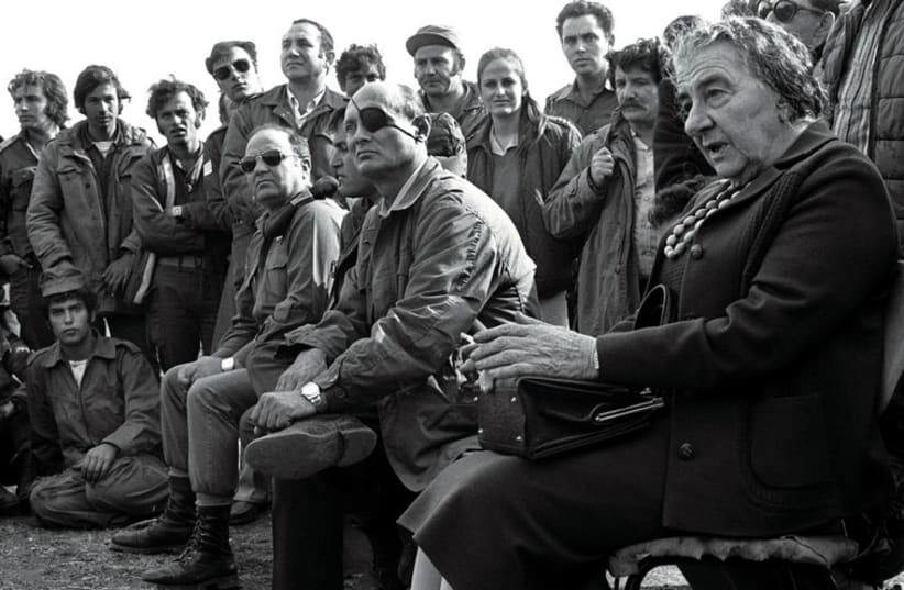Then-prime minister Golda Meir (R) accompanied by then-defense minister Moshe Dayan, meets with Israeli soldiers at a base on the Golan Heights after intense fighting during the 1973 Yom Kippur War. (photo credit: REUTERS)