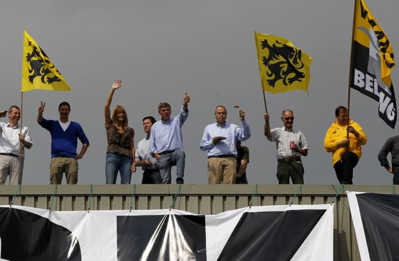 Belgium's Flemish right wing Vlaams Belang party leader Filip Dewinter and supporters wave Flemish flags (photo credit: REUTERS)