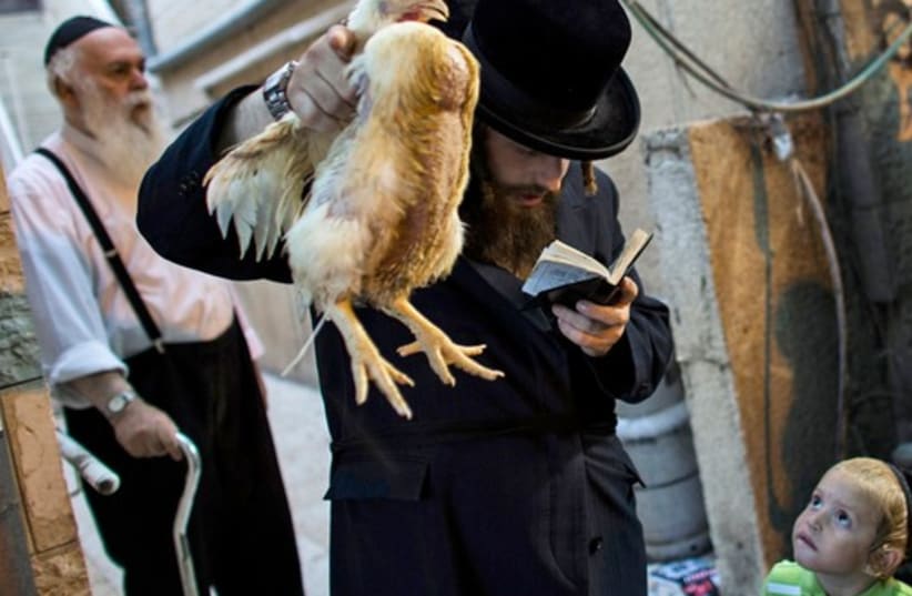 A man performs the ancient Jewish ritual of kaparot (photo credit: REUTERS)