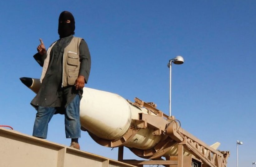 AN ISIS member rides on a rocket launcher in Raqqa in Syria two months ago (photo credit: REUTERS)