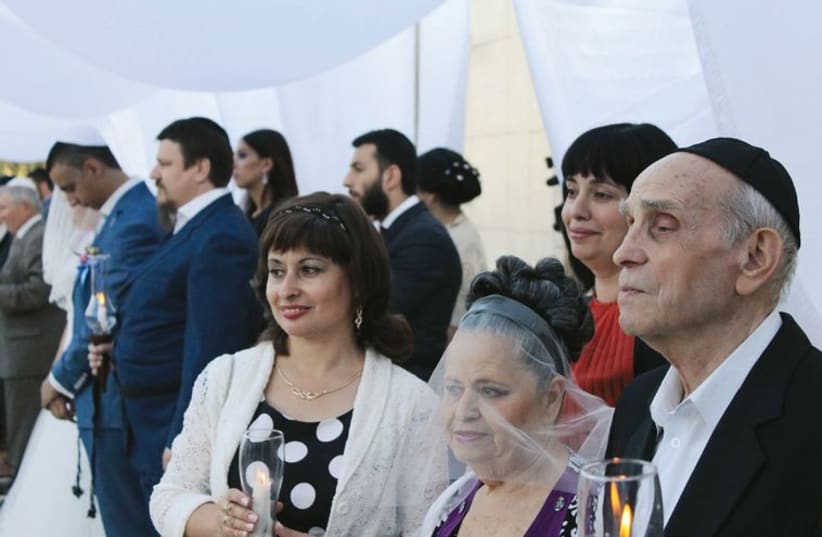 Jewish couples some of them refugees, gather for a mass wedding ceremony, to be married according to Jewish law under the auspices of Chabad. (photo credit: SAM SOKOL)
