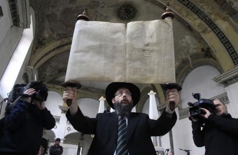 Rabbi Baruch Oberlander holds up a Torah scroll (photo credit: REUTERS)