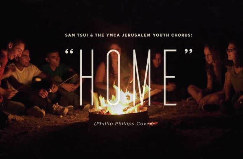 The Jerusalem Youth Chorus sits at a bonfire in a still from the music video ‘Home,’ a collaboration with American singer Sam Tsui. (photo credit: screenshot)