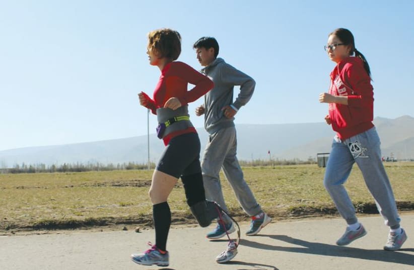 Otgon, wearing her prosthetic, trains for a marathon. She is leading the charge for change in Mongolia as to how people with disabilities are viewed. (photo credit: COURTESY SUCCESS CHAIN)