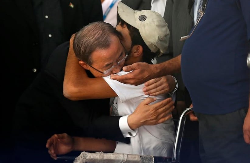 United Nations Secretary-General Ban Ki-moon (L) hugs wheelchair-bound Palestinian Mohammed Abed al-Dayem at a UN-run school in the northern Gaza Strip (photo credit: REUTERS)