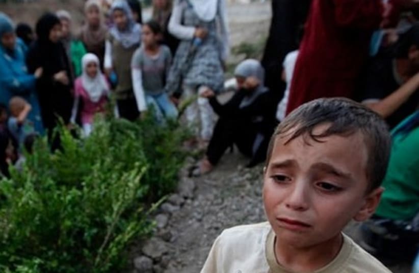 Syrian refugee boy cries as he attends the funeral of five Free Syrian Army fighter near Idlib (photo credit: REUTERS)
