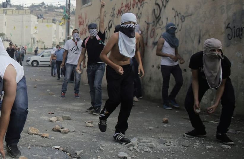 Palestinian youths hurl stones during clashes with Israeli police in the East Jerusalem neighborhood of Wadi Joz, September 7. (photo credit: AMMAR AWAD / REUTERS)