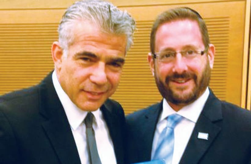 MK DOV LIPMAN (right) hands the ‘Separate in Peace, Live in Peace’ booklet to Finance Minister Yair Lapid yesterday. (photo credit: Courtesy)
