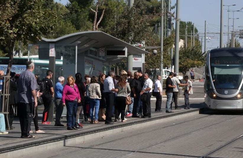 Jerusalem residents waiting at light rail stop at Ammunition Hill, October 23, 2014. (photo credit: MARC ISRAEL SELLEM)