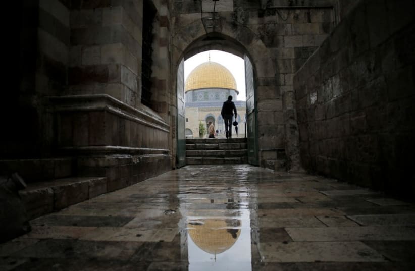 A visitor walks toward the Dome of the Rock as he enters the compound known to Muslims as Noble Sanctuary and to Jews as Temple Mount, in Jerusalem's Old City (photo credit: REUTERS)