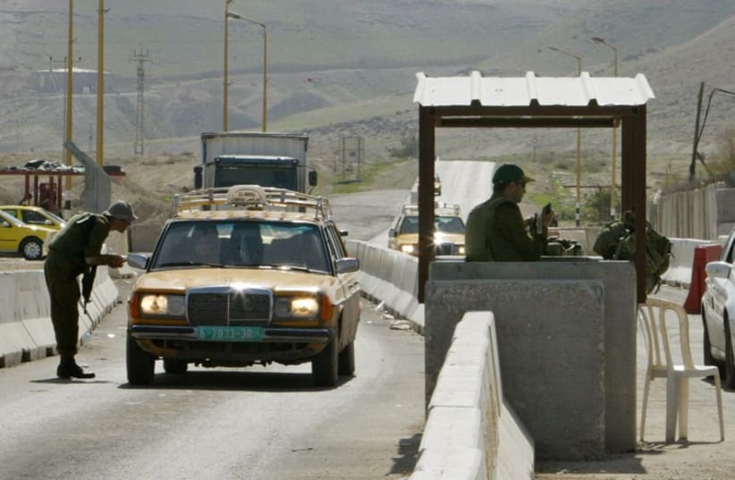 Israeli soldiers check cars at a checkpoint near the West Bank City of Jericho (photo credit: REUTERS)