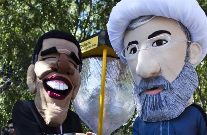 Members of international advocacy group Avaaz take part in a protest wearing masks of Iran's new President Hassan Rouhani (R) and US president Barack Obama, outside the UN headquarters in New York (photo credit: REUTERS)