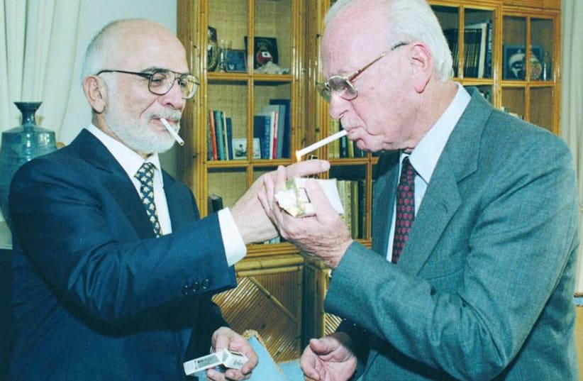 King Hussein of Jordan lights a cigarette for prime minister Yitzhak Rabin at the royal residence in Aqaba in 1994. (photo credit: GPO)