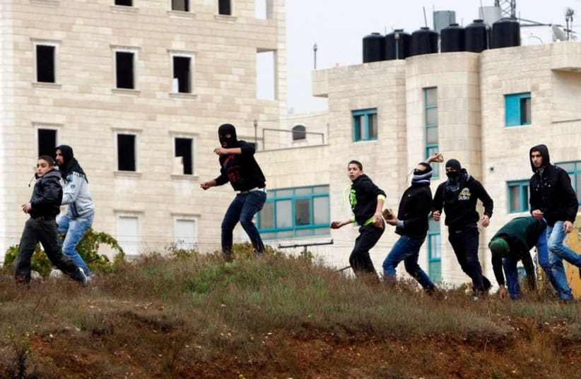 Palestinians throw stones at IDF forces during clashes in the West Bank city of Hebron October 31, 2014. (photo credit: REUTERS)