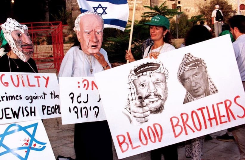 This poster calls both Rabin and PLO then-chairman Arafat "blood brothers" (photo credit: REUTERS)