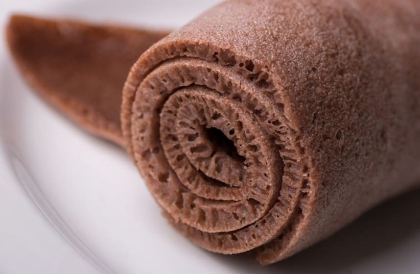 A Roll of Injera made from black teff on a white plate (photo credit: INGIMAGE)