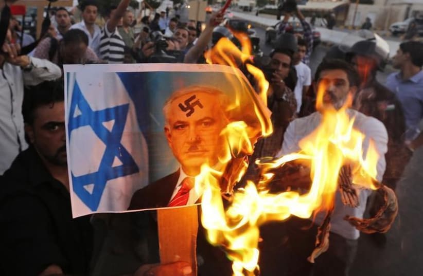 Jordanian opposition members burn a picture of Prime Minister Binyamin Netanyahu in Amman (photo credit: REUTERS)
