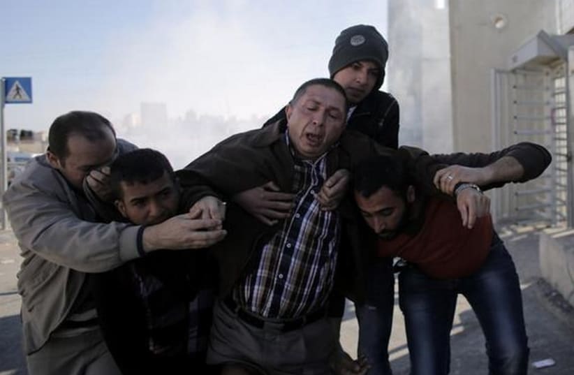 Palestinians react to tear gas fired at rioters in Jerusalem (photo credit: REUTERS)