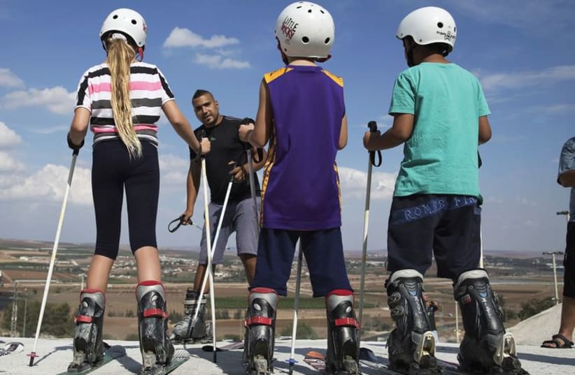 Kids receive instructions on how to ski at an artificial ski slope near Afula in the Jezreel Valley, October 15 (photo credit: FINBARR O'REILLY / REUTERS)