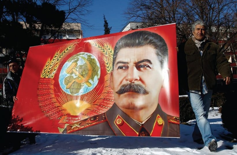 PEOPLE CARRY a poster with a portrait of late Soviet dictator Josef Stalin (photo credit: REUTERS)