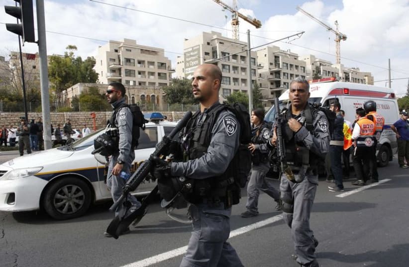 Israeli border police officers walk at the scene of a terror attack in Jerusalem (photo credit: REUTERS)