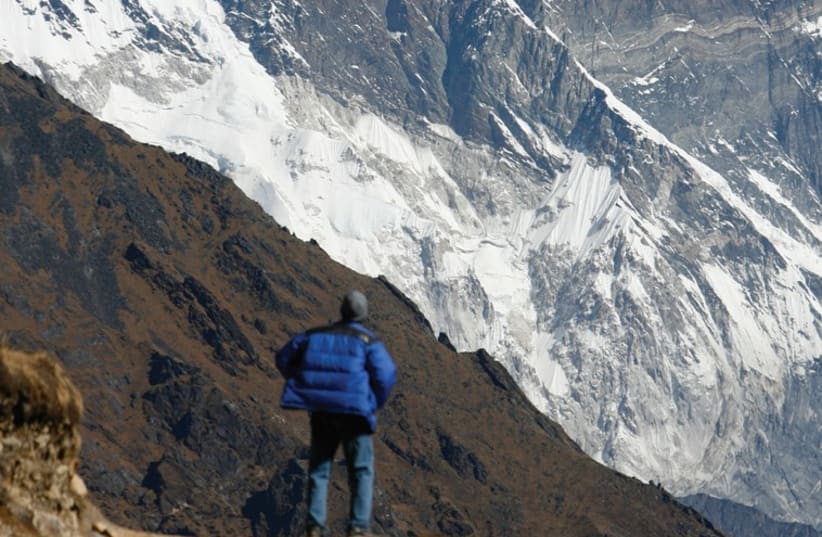 A TOURIST looks at a view of Mount Everest from the hills of Syangboche in Nepal (photo credit: REUTERS)