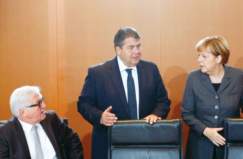 German economy Minister Sigmar Gabriel and Foreign Minister Frank-Walter Steinmeier talk to Chancellor Angela Merkel prior to a cabinet meeting at the Chancellery in Berlin on November 12. (photo credit: REUTERS)