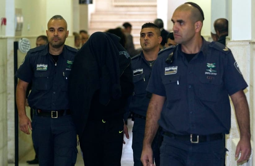Israeli prison guards escort a paramilitary border policeman at Jerusalem District court November 23, 2014. Israeli prosecutors charged the policeman on Sunday in the fatal shooting of a teenage Palestinian protester. (photo credit: REUTERS)