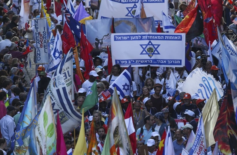 Evangelical Christians from around the world wave their national flags along with Israeli flags as they march in a parade in Jerusalem to mark the Feast of Tabernacles  (photo credit: JNS.ORG)
