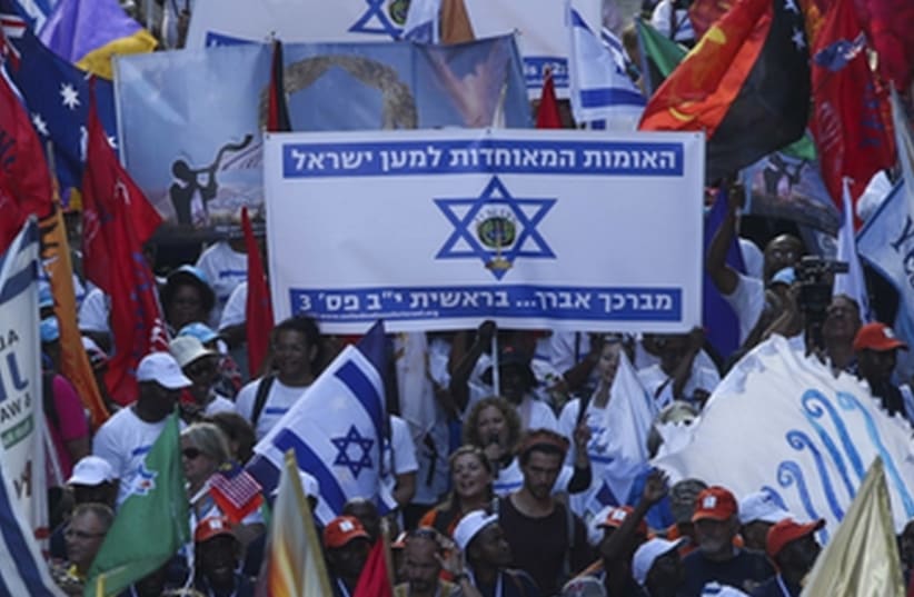 Evangelical Christians from around the world wave their national flags along with Israeli flags as they march in a parade in Jerusalem to mark the Feast of Tabernacles  (photo credit: JNS.ORG)