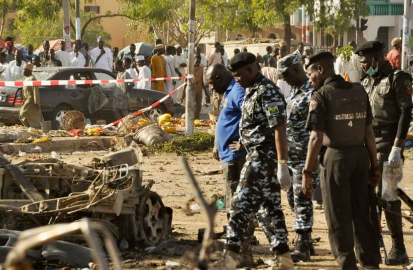Security forces inspect the wreckage of a car believed to be used in Kano attack (photo credit: REUTERS)