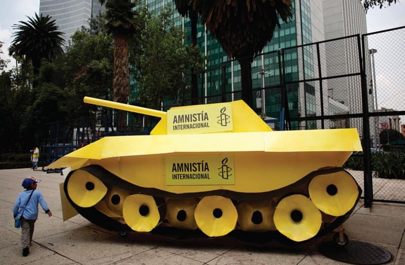A child walks around a fake tank parked outside the US embassy during a protest held by Amnesty International in Mexico City. (photo credit: REUTERS)